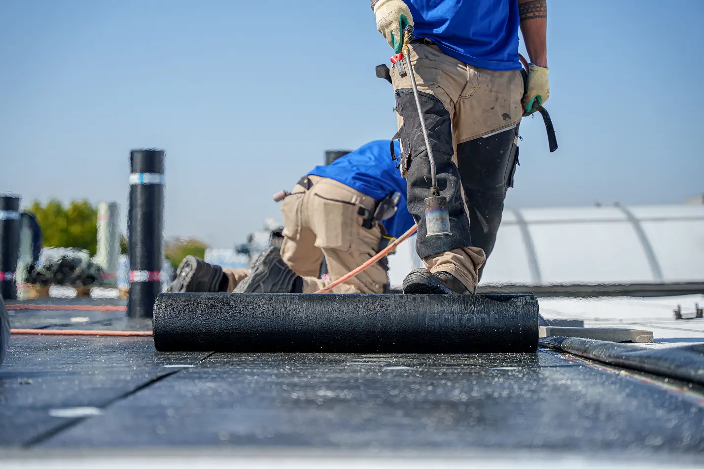 Actiefoto op het dak van medewerkers van Gielen Dakbedekkingen die aan het werk zijn