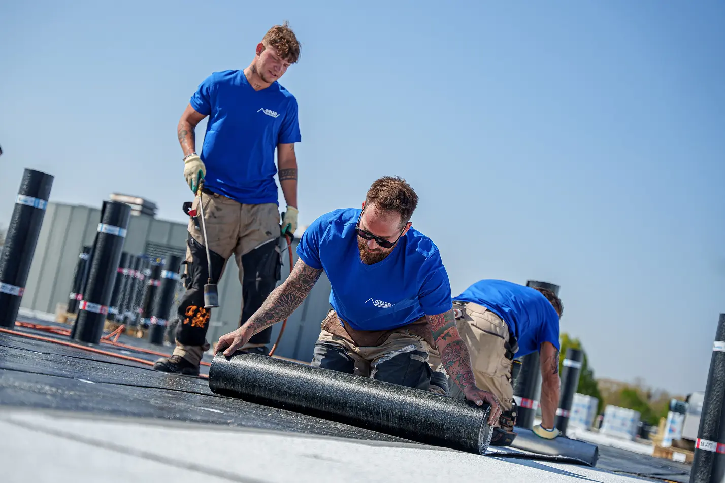Actiefoto op het dak van medewerkers van Gielen Dakbedekkingen die aan het werk zijn